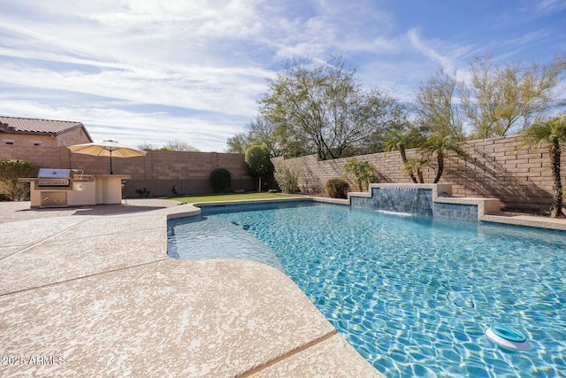 view of swimming pool featuring grilling area, an outdoor kitchen, pool water feature, and a patio area