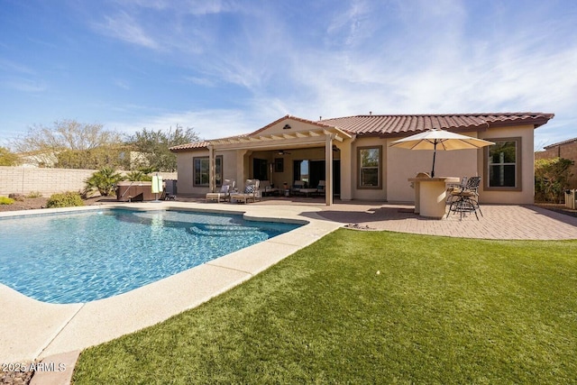 view of swimming pool with a patio, a lawn, and a bar