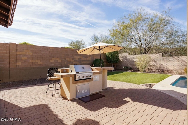 view of patio with area for grilling, exterior kitchen, and an outdoor bar