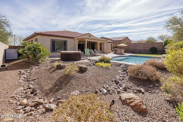 back of house featuring a patio and a pool with hot tub