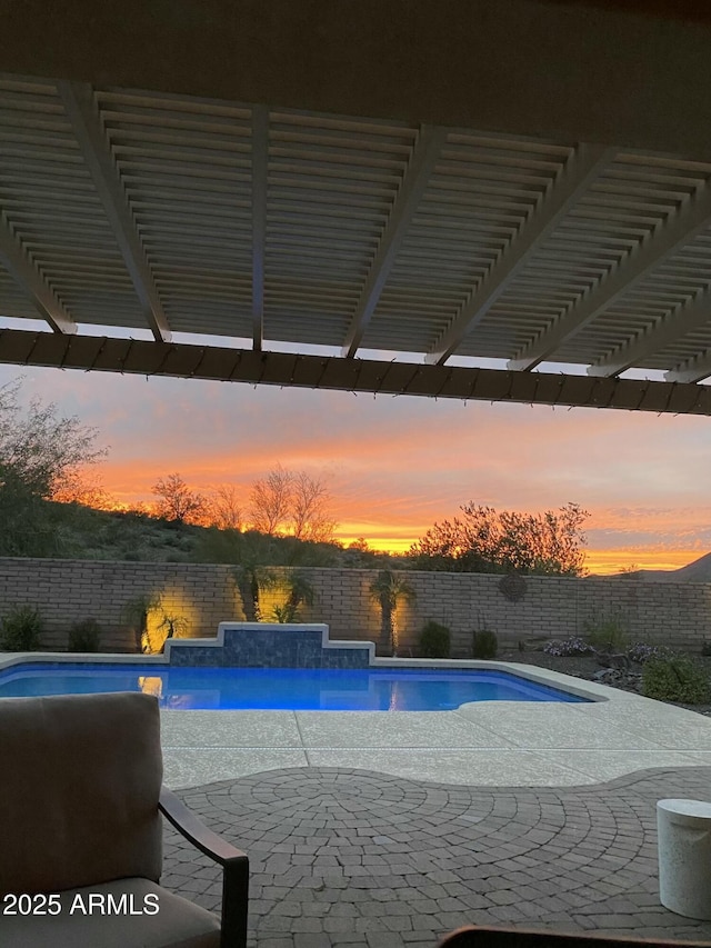 pool at dusk with a pergola and a patio