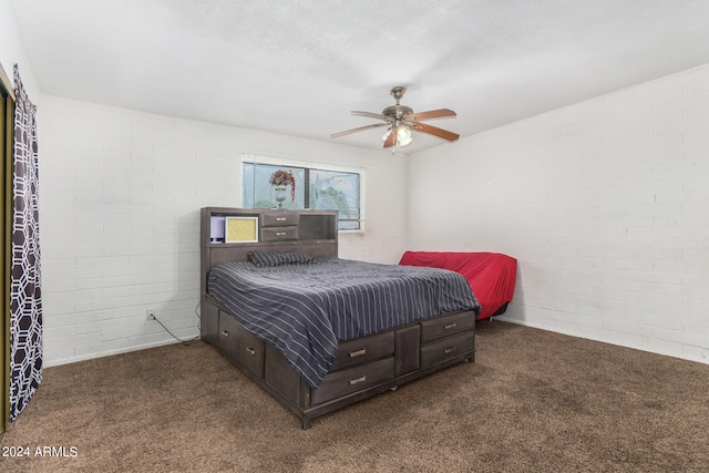 carpeted bedroom with ceiling fan and brick wall