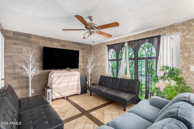 living room with ceiling fan and a textured ceiling