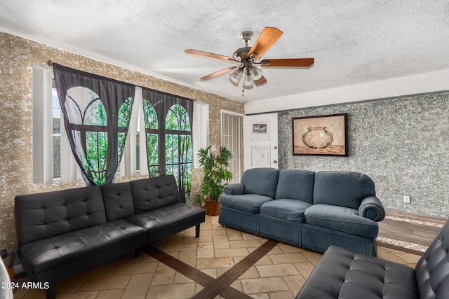 living room featuring ceiling fan and a textured ceiling