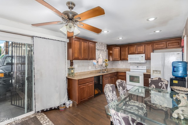 kitchen featuring dark wood-type flooring, backsplash, white appliances, ceiling fan, and sink