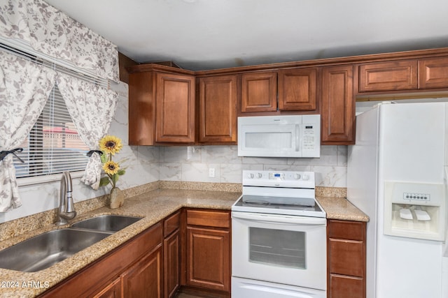 kitchen featuring white appliances, sink, and tasteful backsplash