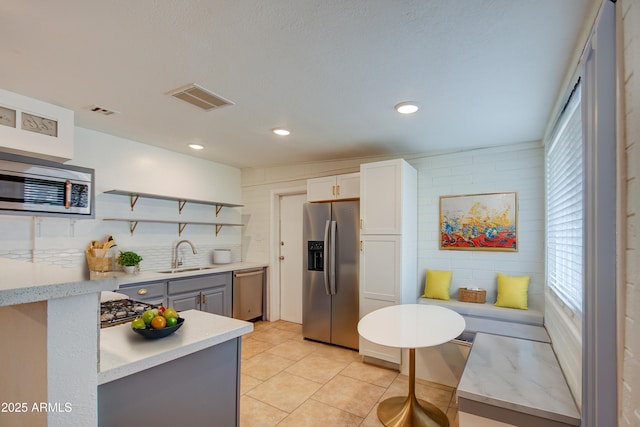 kitchen featuring gray cabinetry, sink, appliances with stainless steel finishes, plenty of natural light, and white cabinetry