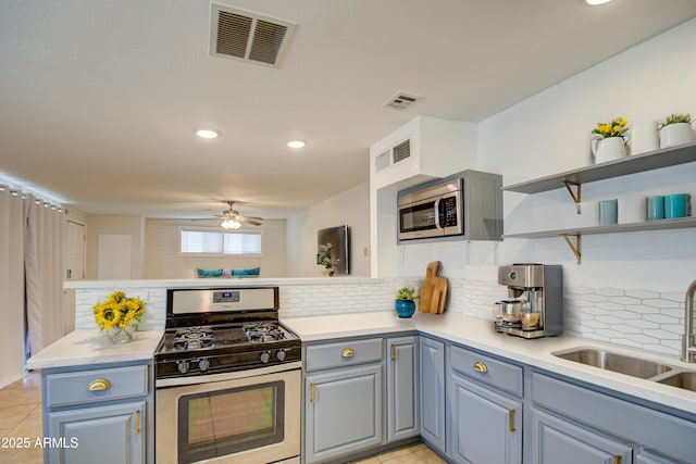 kitchen with sink, ceiling fan, tasteful backsplash, kitchen peninsula, and stainless steel appliances