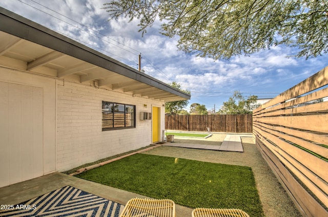 view of yard with a wall mounted air conditioner and a patio