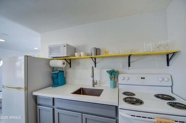 kitchen with white appliances, gray cabinetry, and sink