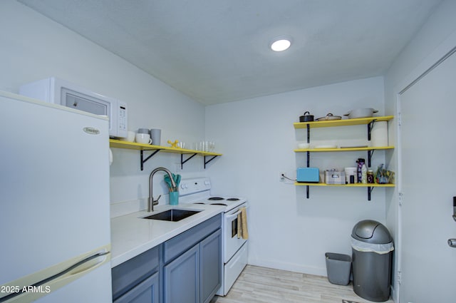 kitchen with gray cabinetry, light wood-type flooring, white appliances, and sink