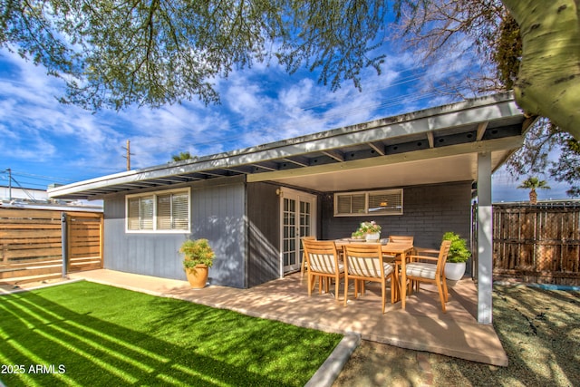 rear view of property featuring a lawn and a patio