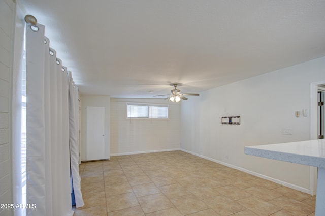 unfurnished room featuring ceiling fan and light tile patterned floors