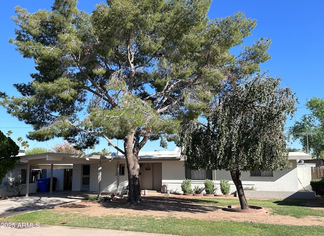 view of front of home with an attached carport, driveway, and a front lawn