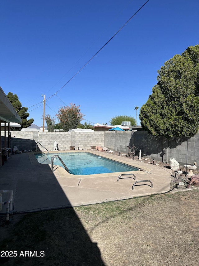 view of swimming pool with a fenced backyard and a patio