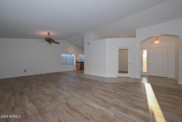 unfurnished living room with ceiling fan, lofted ceiling, and light wood-type flooring