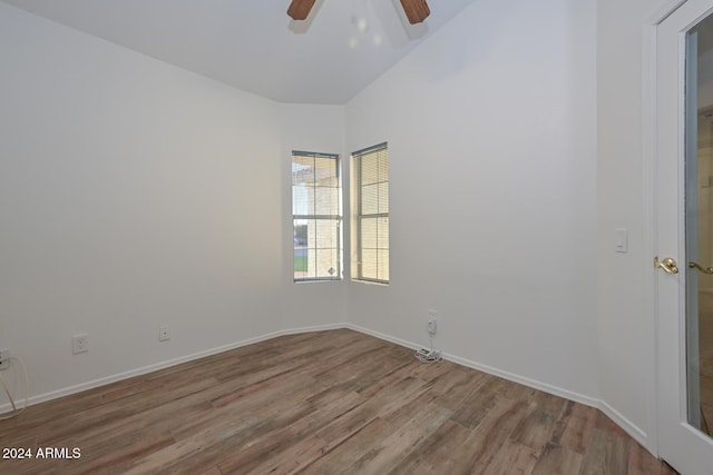 empty room featuring ceiling fan, wood-type flooring, and vaulted ceiling