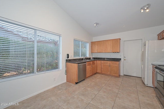 kitchen with light tile patterned floors, stainless steel appliances, vaulted ceiling, and sink