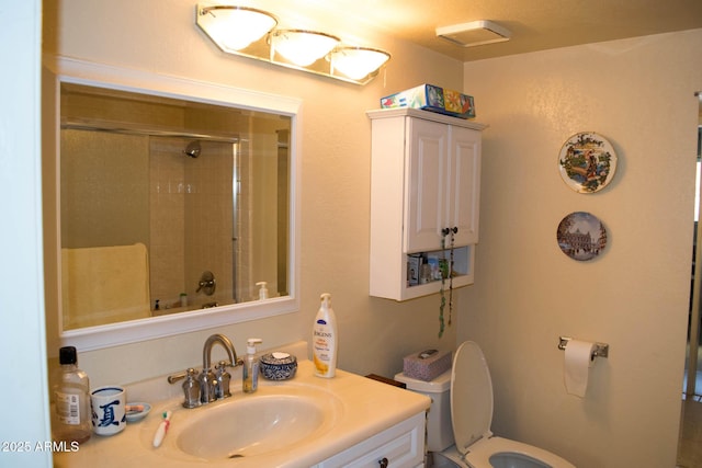 bathroom featuring vanity, a shower with shower door, and toilet