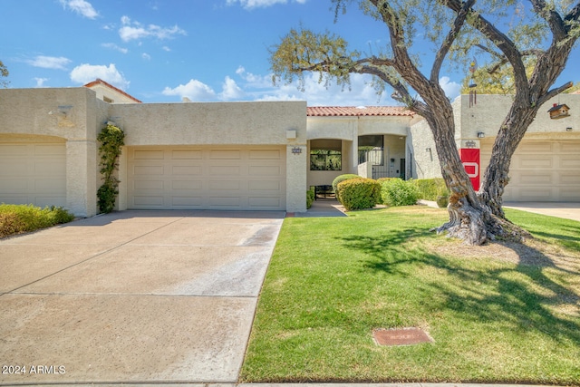 mediterranean / spanish-style house featuring a garage and a front lawn