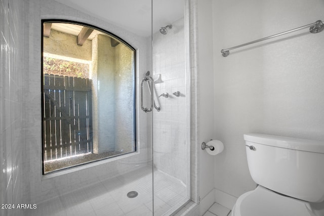 bathroom with walk in shower, tile patterned flooring, and toilet