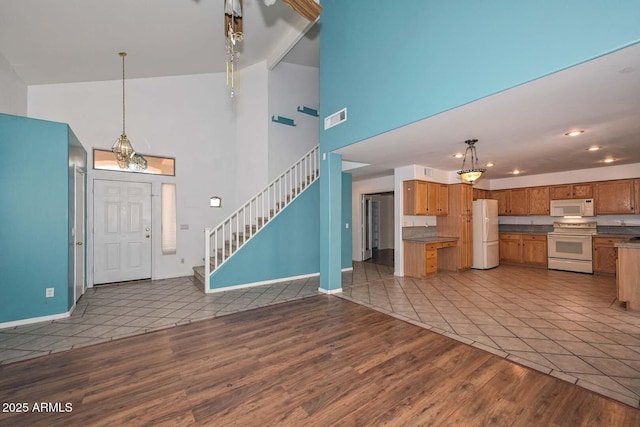 16828 W Windermere Way, Surprise, AZ 85374 - kitchen featuring white appliances, high vaulted ceiling, wood finished floors, brown cabinets, and pendant lighting