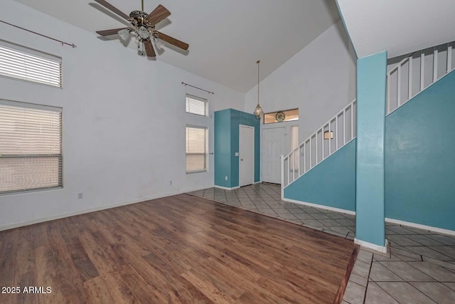 16828 W Windermere Way, Surprise, AZ 85374 - unfurnished living room with high vaulted ceiling, stairway, ceiling fan, and tile patterned floors