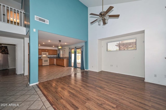 16828 W Windermere Way, Surprise, AZ 85374 - unfurnished living room featuring a high ceiling, a ceiling fan, and wood finished floors