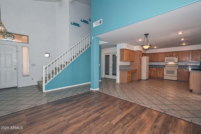 16828 W Windermere Way, Surprise, AZ 85374 - kitchen featuring white appliances, a towering ceiling, dark countertops, dark wood finished floors, and open floor plan