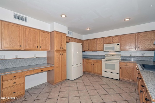 16828 W Windermere Way, Surprise, AZ 85374 - kitchen featuring white appliances, built in study area, light tile patterned flooring, brown cabinetry, and recessed lighting