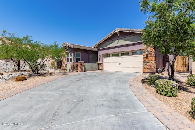 12035 S 186th Ave, Goodyear, AZ 85338 - view of front of home featuring stone siding, concrete driveway, a garage, and stucco siding