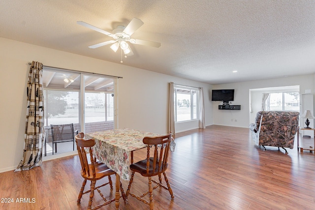 dining room with hardwood / wood-style floors, a textured ceiling, a healthy amount of sunlight, and ceiling fan