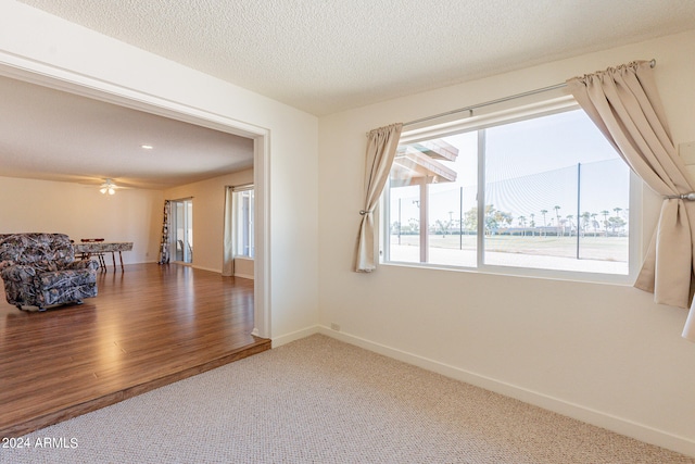 unfurnished room featuring ceiling fan, hardwood / wood-style flooring, and a textured ceiling