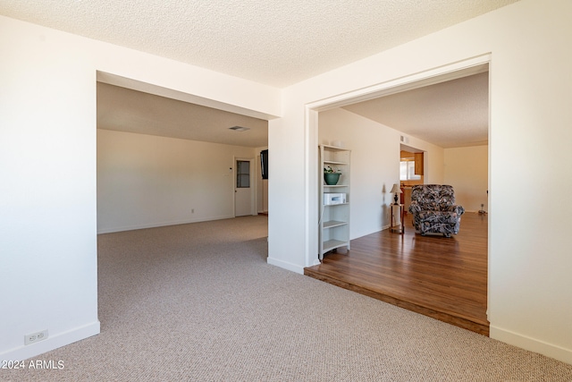 unfurnished room featuring a textured ceiling and wood-type flooring