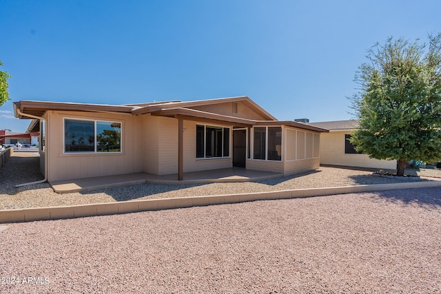 back of property with a patio and a sunroom