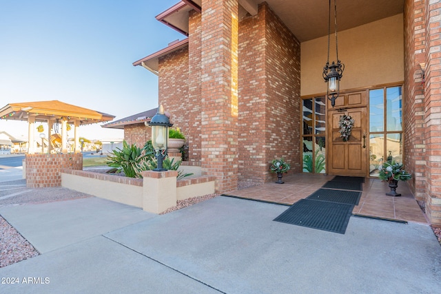 view of exterior entry with a patio