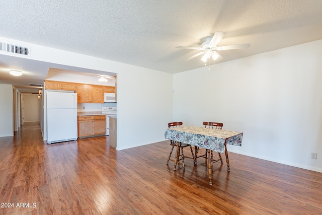 dining room with a textured ceiling, dark wood-type flooring, and ceiling fan