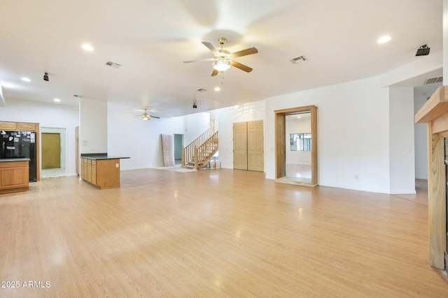 unfurnished living room featuring ceiling fan, stairs, a high end fireplace, light wood-style floors, and recessed lighting