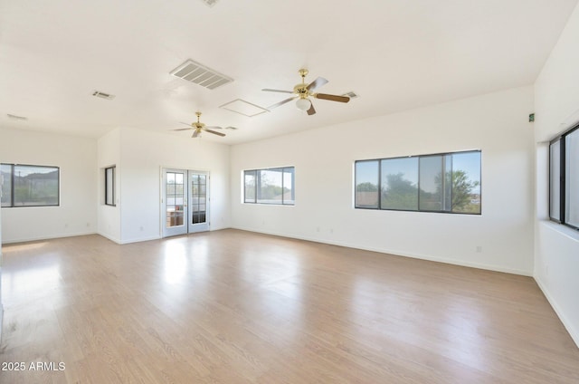 empty room with ceiling fan, light wood finished floors, and baseboards