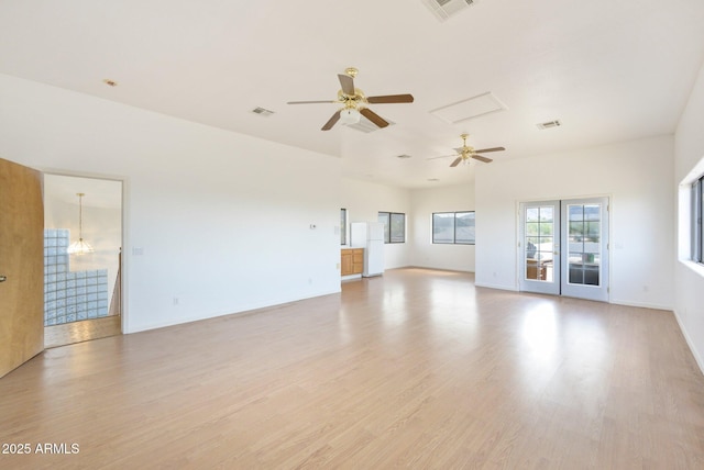 unfurnished living room with a ceiling fan, light wood-type flooring, a chandelier, and baseboards