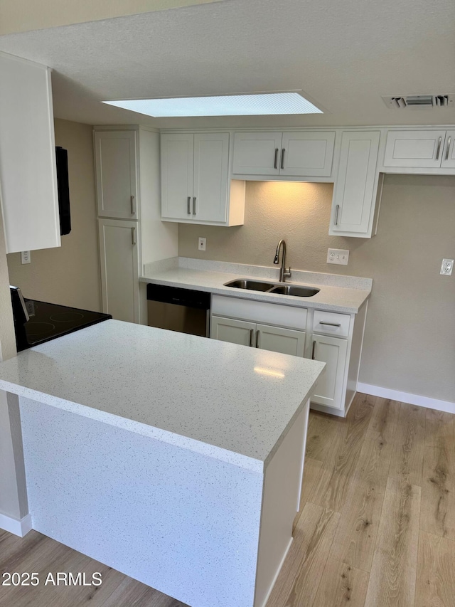 6810 N 35th Ave Unit H, Phoenix, AZ 85017 - kitchen featuring a sink, dishwasher, light wood-style flooring, light stone countertops, and baseboards