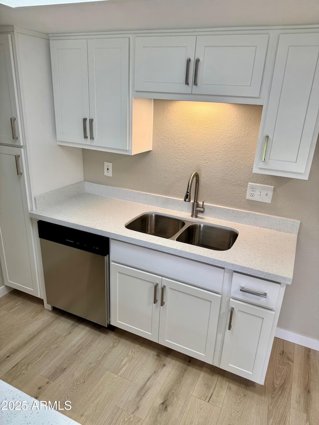 6810 N 35th Ave Unit H, Phoenix, AZ 85017 - kitchen featuring stainless steel dishwasher, a sink, light wood-style flooring, white cabinetry, and baseboards