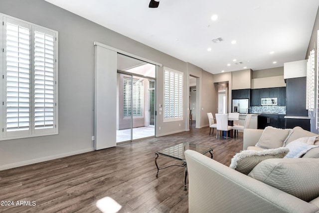 living room with a wealth of natural light, ceiling fan, and dark hardwood / wood-style floors