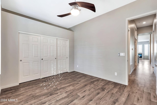 unfurnished bedroom featuring a closet, ceiling fan, and dark wood-type flooring