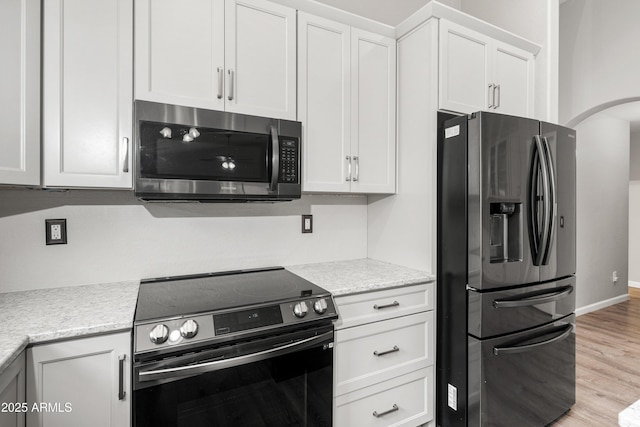 1015 E Penny Ln, San Tan Valley, AZ 85140 - kitchen featuring appliances with stainless steel finishes, white cabinets, light wood-type flooring, baseboards, and light stone counters