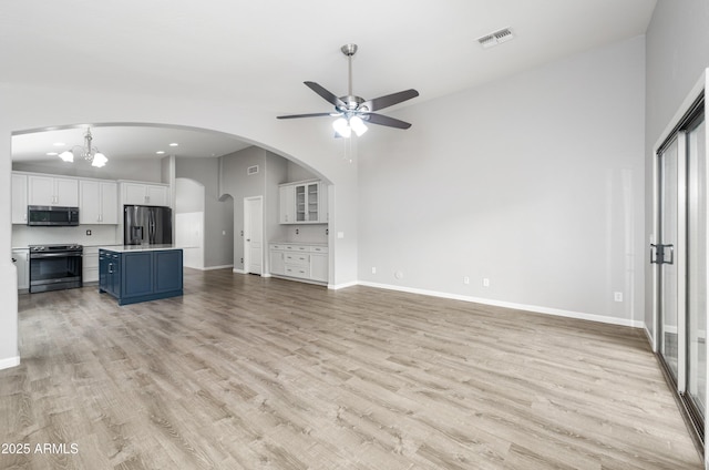 1015 E Penny Ln, San Tan Valley, AZ 85140 - unfurnished living room with a ceiling fan, light wood-style floors, baseboards, and vaulted ceiling