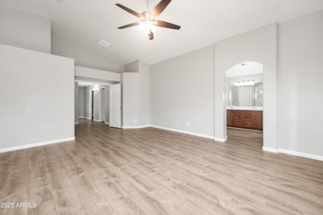 1015 E Penny Ln, San Tan Valley, AZ 85140 - unfurnished living room with ceiling fan, light wood-style flooring, vaulted ceiling, arched walkways, and baseboards