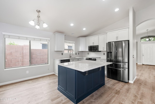 1015 E Penny Ln, San Tan Valley, AZ 85140 - kitchen with stainless steel fridge, range with electric cooktop, white cabinetry, a kitchen island, and lofted ceiling