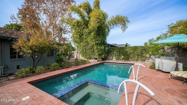 view of pool with an in ground hot tub and a patio