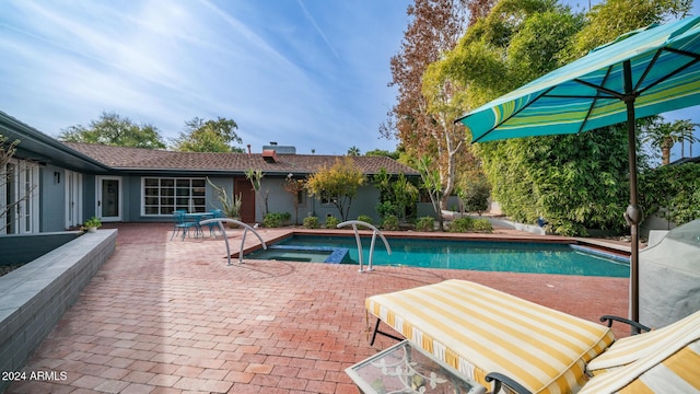 view of swimming pool featuring an in ground hot tub and a patio